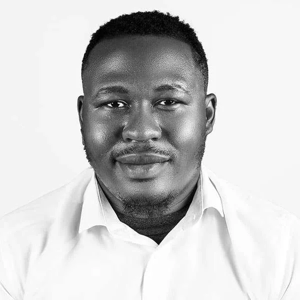 Man in white shirt, neutral expression.